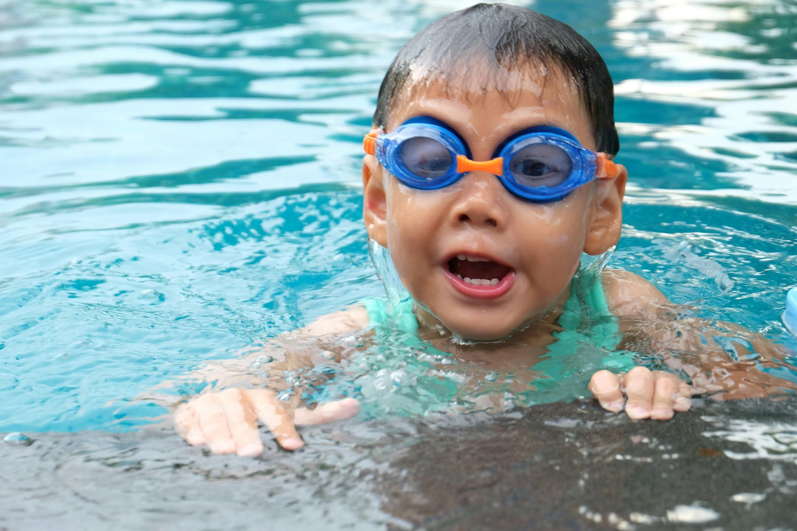 Young child playing and swimming in a pool, enjoying the water.